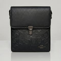 Coach black signature embossed flap messenger bag with metal push lock closure.