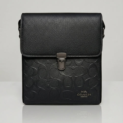 Coach black signature embossed flap messenger bag with metal push lock closure.
