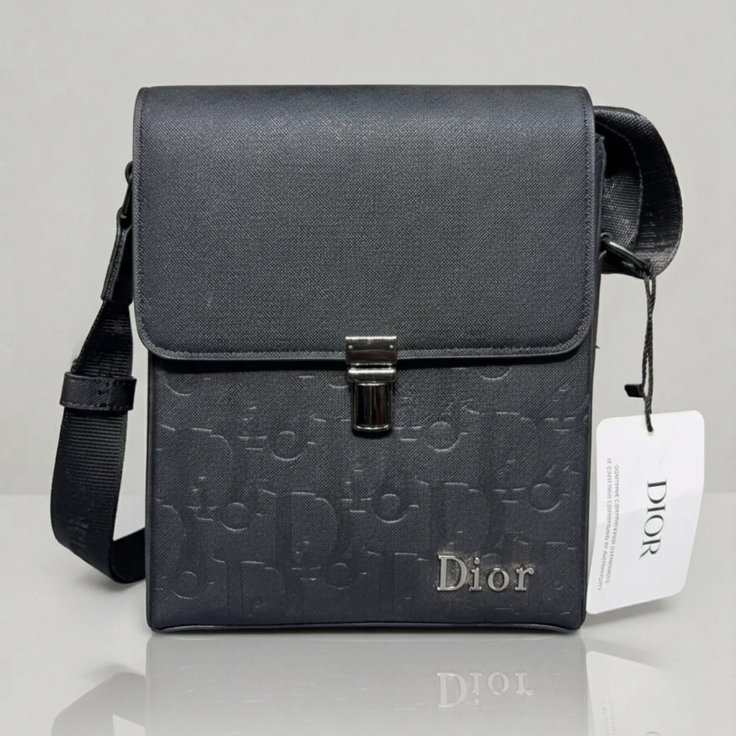 Dior black Oblique embossed flap messenger bag with metal push lock closure.