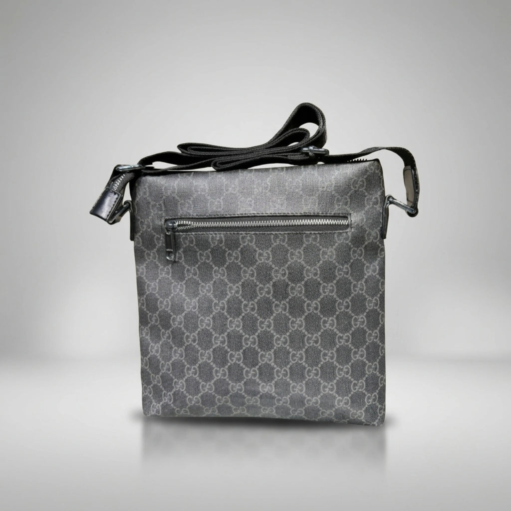 Gucci GG Supreme black canvas flat crossbody bag with leather trim and silver Double G emblem.