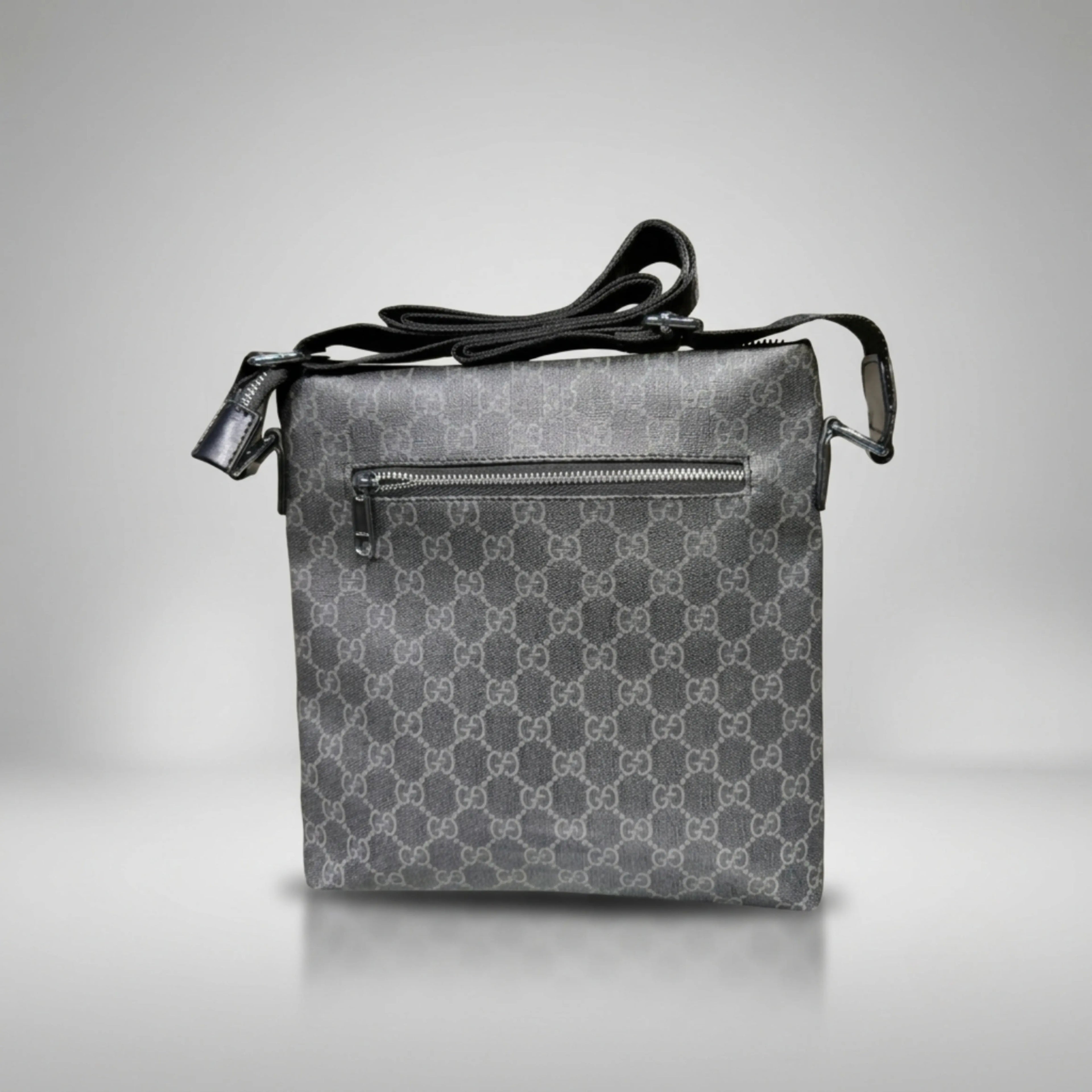 Gucci GG Supreme black canvas flat crossbody bag with leather trim and silver Double G emblem.
