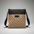 Gucci beige GG canvas flat crossbody bag with black top trim and leather logo patch.