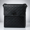 Gucci black Guccissima embossed leather flap messenger bag with matte black Double G emblem.
