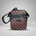 Louis Vuitton brown Damier Ebene canvas crossbody bag with front zip pocket and shoulder strap.